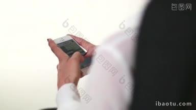 办公室里的女人在用她的智能手机聊天和发送信息